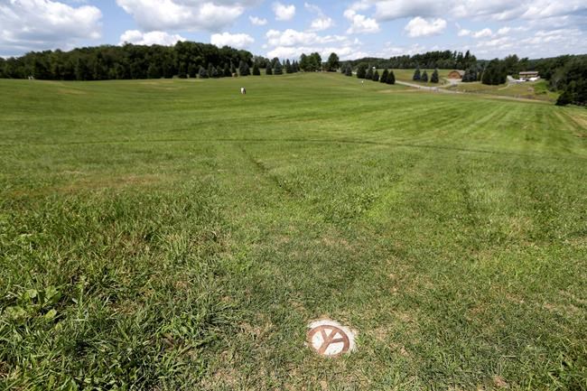 A small peace sign is set into the grass at the site of the 1969 Woodstock Music and Arts Fair, Wednesday, July 24, 2019 in Bethel, N.Y. Woodstock will be celebrated on its 50th anniversary, but it won't be your hippie uncle's trample-the-fences concert. While plans for a big Woodstock 50 festival collapsed after a run of calamities, the bucolic upstate New York site of the 1969 show is hosting a long weekend of events featuring separate shows by festival veterans like Carlos Santana and John Fogerty. (AP Photo/Seth Wenig)