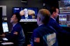 Traders work on the floor of the New York Stock Exchange, Wednesday, Nov. 13, 2019, as House Intelligence Committee Chairman Adam Schiff, of Calif., delivers his opening remarks. Stocks are opening slightly lower on Wall Street led by declines in banks and industrial companies. (AP Photo/Richard Drew)