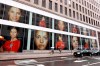 Portraits of the USA women's soccer team members are visible in the windows of a building on Fifth Avenue, in New York, Thursday, June 13, 2019. Women's soccer engages the U.S. every four years, then disappears for most fans like Brigadoon. In the wake of the Americans' record-setting fourth World Cup title Sunday, July 7, 2019, the hard part remains ahead: the weekly work of boosting the National Women's Soccer League. (AP Photo/Richard Drew)