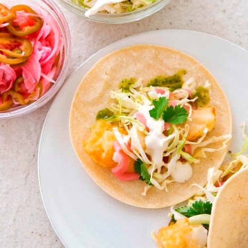 This undated photo provided by America's Test Kitchen in May 2019 shows California-Style Fish Tacos in Brookline, Mass. This recipe appears in the cookbook ‚ÄúNew Essentials.‚Äù (Joe Keller/America's Test Kitchen via AP)