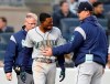 Seattle Mariners manager Scott Servais, right, and a Mariners trainer check on Dee Gordon, center, who was hit by a pitch during the third inning of the team's baseball game against the New York Yankees, Thursday, May 9, 2019, in New York. Gordon was removed from the game. (AP Photo/Kathy Willens)