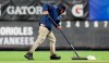 A groundskeeper uses a squeegee to remove water from the field at Yankee Stadium before a baseball game between the New York Yankees and the Baltimore Orioles, Monday, May 13, 2019, in New York. The game was postponed until Wednesday afternoon due to unplayable field conditions. (AP Photo/Kathy Willens)