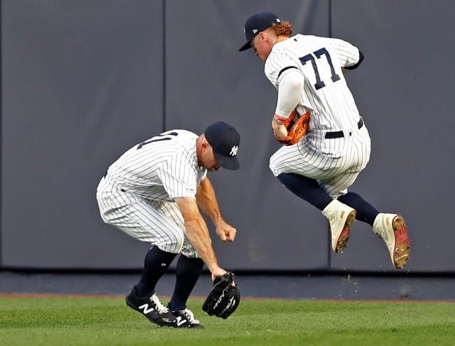 New York Yankees right fielder Clint Frazier (77) leaps to allow Yankees center fielder Brett Gardner (11) to field an RBI single by New York Mets' Michael Conforto during the third inning of a baseball game Tuesday, June 11, 2019, in New York. (AP Photo/Kathy Willens)