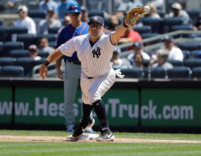 New York Yankees first baseman Kendrys Morales can't field the throw allowing New York Mets' Todd Frazier to reach first base during the fourth inning in the first baseball game of a doubleheader, Tuesday, June 11, 2019, in New York. (AP Photo/Frank Franklin II)