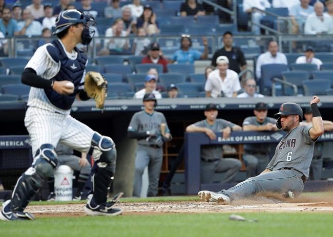 Arizona Diamondbacks' David Peralta (6) slides in to score on a sacrifice fly by Adam Jones, next to New York Yankees catcher Kyle Higashioka during the first inning of a baseball game Tuesday, July 30, 2019, in New York. The Diamondbacks won 4-2. (AP Photo/Frank Franklin II)