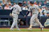 Tampa Bay Rays' third base coach Rodney Linares (27) slaps hands with Travis d'Arnaud who runs the bases after hitting a solo home run during the first inning of a baseball game against the New York Yankees, Monday, July 15, 2019, in New York. (AP Photo/Kathy Willens)