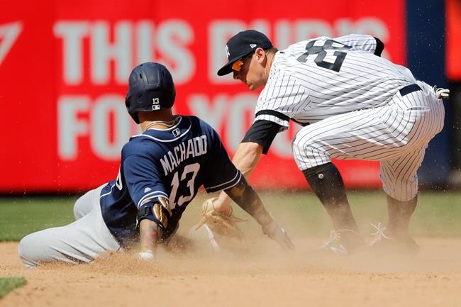 San Diego Padres' Manny Machado (13) slides safely into second base against New York Yankees second baseman DJ LeMahieu, right, during the ninth inning of an baseball game, Monday, May 27, 2019, in New York. (AP Photo/Michael Owens)