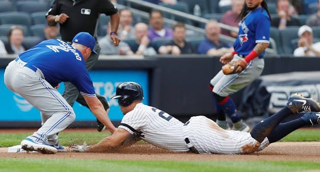 Toronto Blue Jays starting pitcher Clayton Richard, left, tags out New York Yankees' Giancarlo Stanton at third during the first inning of a baseball game Tuesday, June 25, 2019, in New York. Stanton left the game after the third inning. (AP Photo/Kathy Willens)
