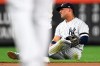 New York Yankees second baseman Gleyber Torres sits on the ground after slipping while trying to field a ground ball during the fourth inning of the team's baseball game against the Toronto Blue Jays, Friday, Sept. 20, 2019, in New York. (AP Photo/Sarah Stier)