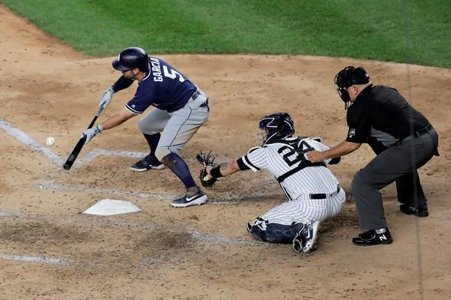 San Diego Padres' Greg Garcia hits a run-scoring bunt single off New York Yankees starting pitcher Masahiro Tanaka during the sixth inning of a baseball game, Tuesday, May 28, 2019, in New York. (AP Photo/Julio Cortez)