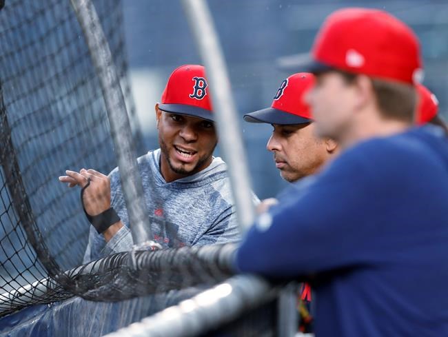 Boston Red Sox's Xander Bogaerts, left, chats with manager Alex Cora behind the batting cage after the team's baseball game against the New York Yankees was postponed Thursday, May 30, 2019, in New York. (AP Photo/Kathy Willens)
