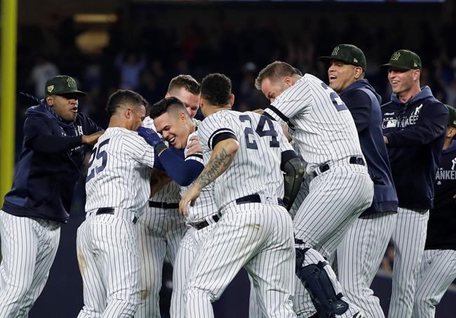 New York Yankees' Gio Urshela celebrates with teammates after hitting a game-ending RBI single during the ninth inning of the team's baseball game against the Tampa Bay Rays on Friday, May 17, 2019, in New York. The Yankees won 4-3. (AP Photo/Frank Franklin II)