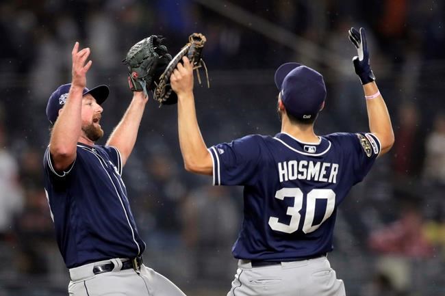 San Diego Padres relief pitcher Kirby Yates, left, and first baseman Eric Hosmer (30) react after defeating the New York Yankees 5-4 in a baseball game, Tuesday, May 28, 2019, in New York. (AP Photo/Julio Cortez)