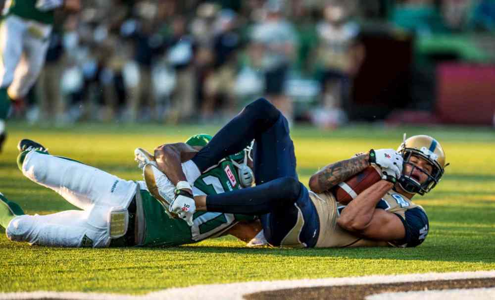 Matt Smith / REUTERS
Winnipeg slotback Nick Moore keeps a firm grip on the ball for a crucial touchdown catch as he's tackled in the end zone by Saskatchewan defensive back Terrell Maze Saturday night in Regina.