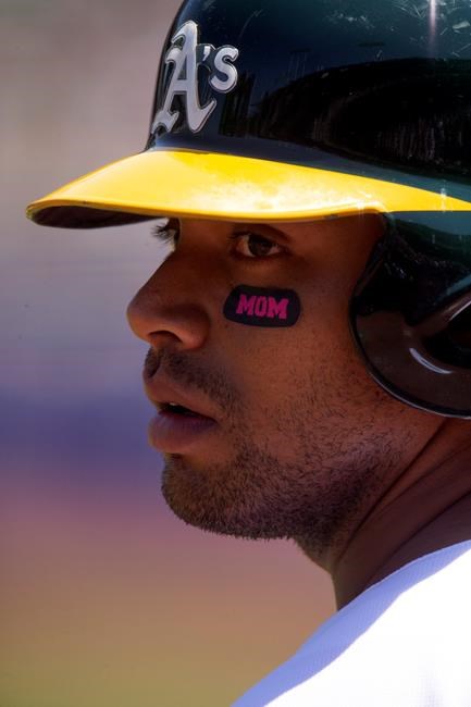 CORRECTS YEAR TO 2019-Oakland Athletics designated hitter Khris Davis (2) sports Mother's Day-themed eye blacks as he waits on deck during the first inning of a baseball game against the Cleveland Indians, Sunday, May 12, 2019, in Oakland, Calif. (AP Photo/D. Ross Cameron)