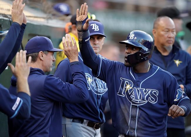 Tampa Bay Rays' Guillermo Heredia, right, is congratulated after scoring against the Oakland Athletics during the third inning of a baseball game Friday, June 21, 2019, in Oakland, Calif. (AP Photo/Ben Margot)