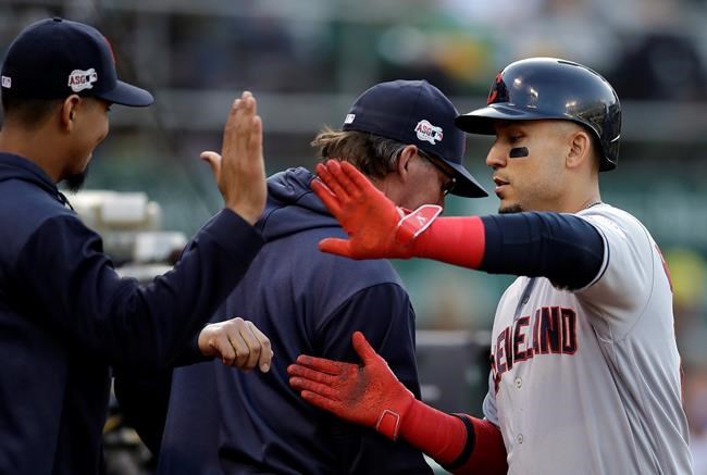 Cleveland Indians' Carlos Gonzalez, right, is congratulated after scoring against the Oakland Athletics during the second inning of a baseball game Friday, May 10, 2019, in Oakland, Calif. (AP Photo/Ben Margot)