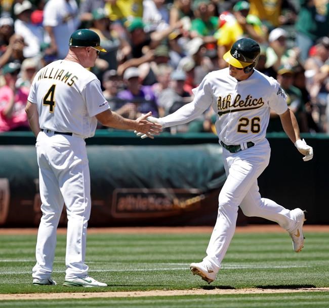 Oakland Athletics' Matt Chapman, right, is congratulated by third base coach Matt Williams (4) after hitting a home run off Tampa Bay Rays' Yonny Chirinos during the third inning of a baseball game Saturday, June 22, 2019, in Oakland, Calif. (AP Photo/Ben Margot)