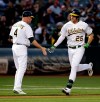 Oakland Athletics' Stephen Piscotty, right, is congratulated by third base coach Matt Williams (4) after hitting a home run off Texas Rangers' Mike Minor in the second inning of a baseball game Monday, April 22, 2019, in Oakland, Calif. (AP Photo/Ben Margot)