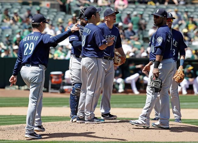 Seattle Mariners' Scott Servais, left, calls for a new pitcher as Yusei Kikuchi, center, is removed in the fourth inning of a baseball game against the Oakland Athletics, Saturday, May 25, 2019, in Oakland, Calif. (AP Photo/Ben Margot)