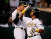 Oakland Athletics' Khris Davis, right, celebrates with Stephen Piscotty after hitting a two-run home run off New York Yankees' J.A. Happ during the second inning of a baseball game Wednesday, Aug. 21, 2019, in Oakland, Calif. (AP Photo/Ben Margot)