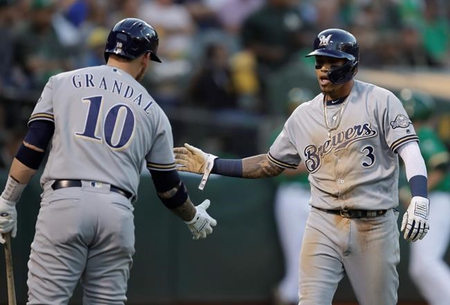 Milwaukee Brewers' Orlando Arcia, right, is congratulated by Yasmani Grandal after scoring against the Oakland Athletics during the third inning of a baseball game Wednesday, July 31, 2019, in Oakland, Calif. (AP Photo/Ben Margot)