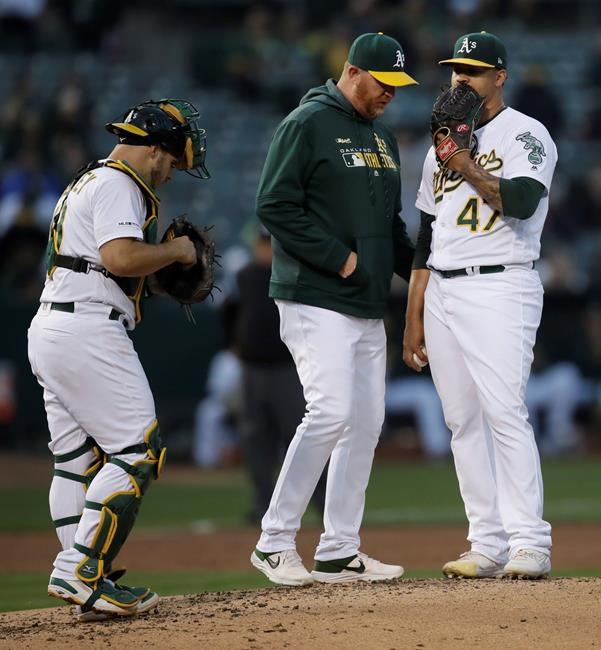 Oakland Athletics pitcher Frankie Montas, right, speaks with pitching coach Scott Emerson in the second inning of a baseball game against the Los Angeles Angels, Tuesday, May 28, 2019, in Oakland, Calif. (AP Photo/Ben Margot)