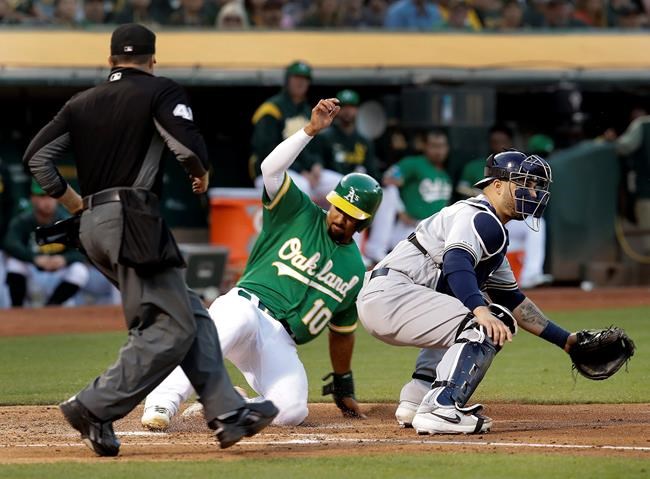Oakland Athletics' Marcus Semien (10) scores past Milwaukee Brewers catcher Manny Pina during the third inning of a baseball game Wednesday, July 31, 2019, in Oakland, Calif. (AP Photo/Ben Margot)