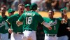 Oakland Athletics' Chad Pinder (18) celebrates with Mark Canha, left, and Franklin Barreto (1) after scoring the game winning run against the Chicago White Sox at the end of a baseball game Sunday, July 14, 2019, in Oakland, Calif. Pinder scored on a throwing error by Chicago's Jose Rondon. (AP Photo/Ben Margot)