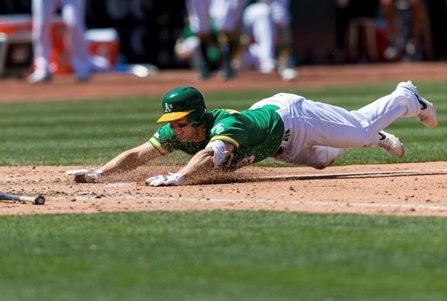 Oakland Athletics Nick Hundley slides in for a solo home run on a throwing error by the Cleveland Indians in the fifth inning of a baseball game Saturday, May 11, 2019, in Oakland, Calif. (AP Photo/John Hefti)