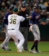 Minnesota Twins' Ehire Adrianza, right, is tagged out stealing home by Oakland Athletics pitcher Yusmeiro Petit in the seventh inning of a baseball game Wednesday, July 3, 2019, in Oakland, Calif. (AP Photo/Ben Margot)