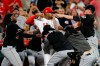 Cincinnati Reds relief pitcher Amir Garrett (50) looks to throw a punch as he is held back by a number of Pittsburgh Pirates players during a brawl in the ninth inning of a baseball game in Cincinnati on Tuesday, July 30, 2019. The Pirates won 11-4. (Sam Greene/The Cincinnati Enquirer via AP)