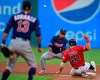 Cleveland Indians' Jason Kipnis (22) slides as Minnesota Twins' Jorge Polanco, center, attempts to field the throw from Ehire Adrianza (13) in the fourth inning of a baseball game, Friday, July 12, 2019, in Cleveland. Jose Ramirez would be safe at first base. (AP Photo/David Dermer)