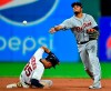 Detroit Tigers' Jeimer Candelario throws to first base after forcing out Cleveland Indians' Oscar Mercado at second base in the seventh inning of a baseball game, Tuesday, July 16, 2019, in Cleveland. Carlos Santana was out at first base. The Indians won 8-0. (AP Photo/David Dermer)