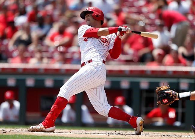 Cincinnati Reds' Jose Iglesias hits an RBI-single off Colorado Rockies starting pitcher Peter Lambert during the second inning of a baseball game, Sunday, July 28, 2019, in Cincinnati. (AP Photo/Gary Landers)