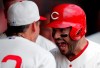 Cincinnati Reds' Eugenio Suarez, right, reacts in the dugout following a three-run home run off Chicago Cubs starting pitcher Jon Lester during the first inning of a baseball game, Sunday, June 30, 2019, in Cincinnati. Reds Derek Dietrich, left, looks on. (AP Photo/Gary Landers)