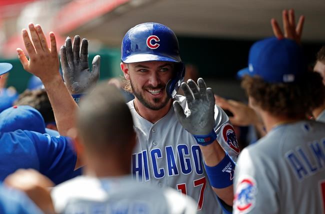 Chicago Cubs' Kris Bryant, center, celebrates a three-run home run off Cincinnati Reds relief pitcher Michael Lorenzen during the seventh inning of a baseball game, Sunday, Aug. 11, 2019, in Cincinnati. (AP Photo/Gary Landers)