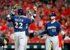 Milwaukee Brewers' Christian Yelich (22) is congratulated at the plate by Yasmani Grandal, obscured, left, and Mike Moustakas (11) following a two-run home run off Cincinnati Reds relief pitcher Robert Stephenson during the ninth inning of a baseball game, Monday, July 1, 2019, in Cincinnati. (AP Photo/Gary Landers)
