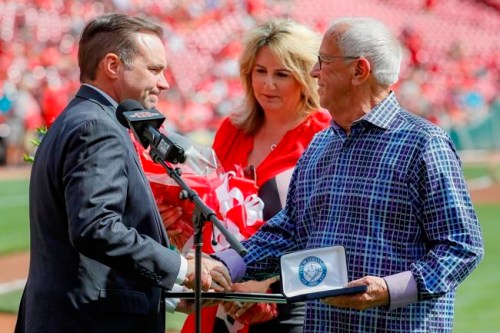 Cincinnati Reds announcer Marty Brennaman, right, shakes hands with Cincinnati Mayor John Cranley, left, alongside his wife Amanda Ingram, center, before a baseball game against the Milwaukee Brewers, Thursday, Sept. 26, 2019, in Cincinnati. The 77-year-old broadcaster is retiring after 46 years. (AP Photo/John Minchillo)