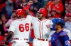 Cincinnati Reds' Yasiel Puig (66) celebrates with Eugenio Suarez, center, after hitting a two-run home run off Texas Rangers starting pitcher Mike Minor during the fourth inning of a baseball game Saturday, June 15, 2019, in Cincinnati. (AP Photo/John Minchillo)