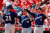From left, Milwaukee Brewers' Travis Shaw, Yasmani Grandal, and Cory Spangenberg celebrate after scoring on a three-run double hit by Orlando Arcia, off Cincinnati Reds starting pitcher Luis Castillo, in the fourth inning of a baseball game, Thursday, Sept. 26, 2019, in Cincinnati. (AP Photo/John Minchillo)