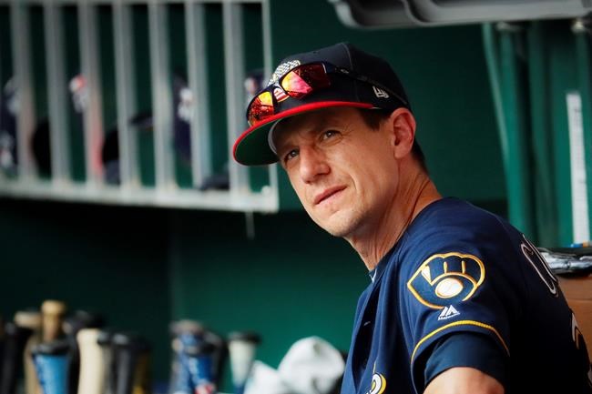Milwaukee Brewers manager Craig Counsell mans the dugout in the seventh inning of a baseball game against the Cincinnati Reds, Thursday, July 4, 2019, in Cincinnati. (AP Photo/John Minchillo)