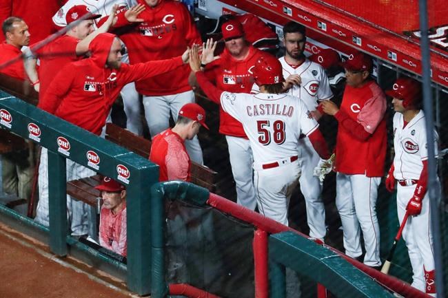 Cincinnati Reds' Luis Castillo (58) celebrates in the dugout after scoring on a wild pitch by Chicago Cubs starting pitcher Jose Quintana during the fifth inning of a baseball game Thursday, May 16, 2019, in Cincinnati. (AP Photo/John Minchillo)