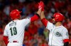 Cincinnati Reds' Joey Votto (19) celebrates with Eugenio Suarez (7) after hitting a solo home run off Chicago Cubs starting pitcher Yu Darvish in the sixth inning of a baseball game, Friday, Aug. 9, 2019, in Cincinnati. (AP Photo/John Minchillo)