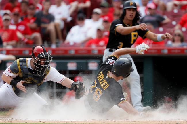 Pittsburgh Pirates' Adam Frazier (26) scores against Cincinnati Reds catcher Tucker Barnhart, left, on a two-run double by Bryan Reynolds off relief pitcher David Hernandez in the eighth inning during the first baseball game of a doubleheader, Monday, May 27, 2019, in Columbus. (AP Photo/John Minchillo)