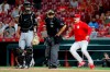 Cincinnati Reds manager David Bell (25) runs up to umpire Larry Vanover, center, to argue a called strike against Yasiel Puig during the ninth inning of a baseball game against the Pittsburgh Pirates on Tuesday, July 30, 2019, in Cincinnati. (AP Photo/John Minchillo)