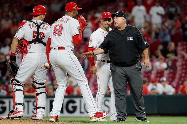 Cincinnati Reds relief pitcher Amir Garrett (50) argues with umpire Eric Cooper, right, during the ninth inning of the team's baseball game against the Pittsburgh Pirates, Tuesday, July 30, 2019, in Cincinnati. (AP Photo/John Minchillo)