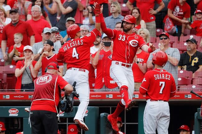 Cincinnati Reds' Jose Iglesias (4) celebrates with Jesse Winker (33) after hitting a grand slam off Pittsburgh Pirates starting pitcher Mitch Keller in the first inning during the second baseball game of a doubleheader, Monday, May 27, 2019, in Columbus, Ohio. (AP Photo/John Minchillo)