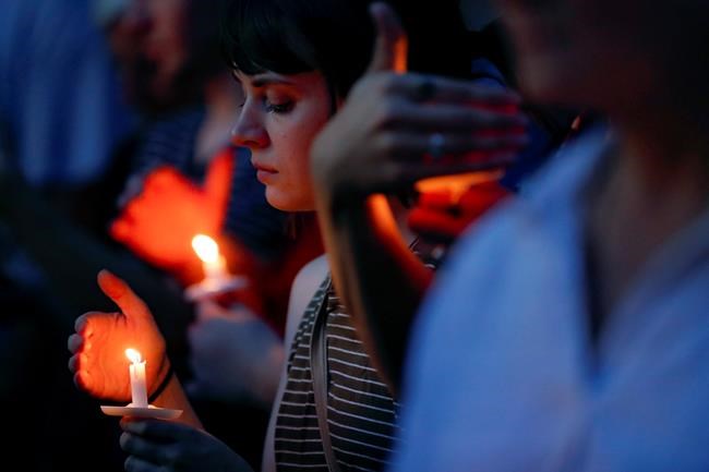 Mourners bow their heads in prayer as they gather for a vigil at the scene of a mass shooting, Sunday, Aug. 4, 2019, in Dayton, Ohio. Multiple people in Ohio were killed in the second mass shooting in the U.S. in less than 24 hours. (AP Photo/John Minchillo)