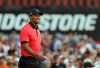 Tiger Woods smiles as walks onto the 18th green during the final round of the Bridgestone Invitational golf tournament Sunday, Aug. 4, 2013 at Firestone Country Club in Akron, Ohio. Woods won the tournament by seven shots with a 15-under par total. (AP Photo/Mark Duncan)